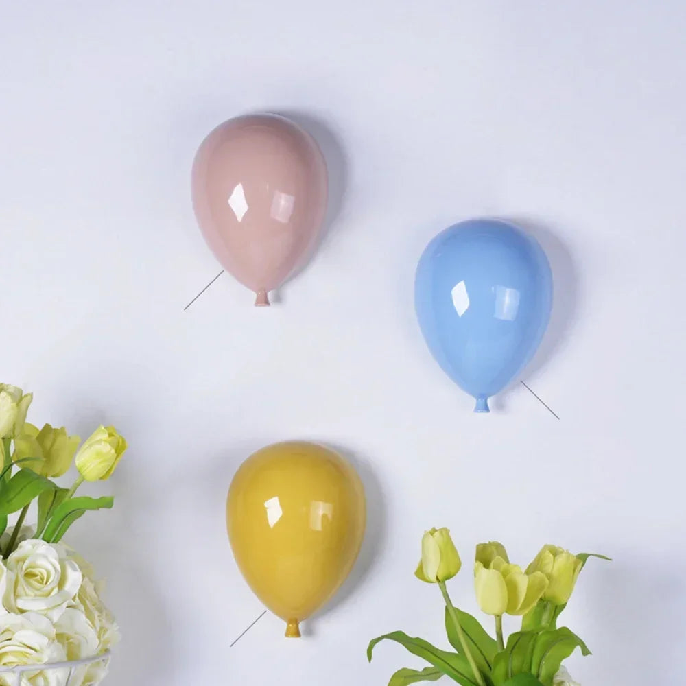 Dekoracyjne lampy dla dzieci w kształcie balonów w kolorze różowym, niebieskim i żółtym na białej ścianie