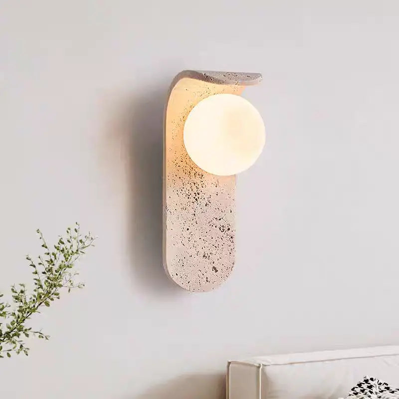 Nowoczesny kinkiet ścienny z okrągłą mleczną lampą i kamienną podstawą