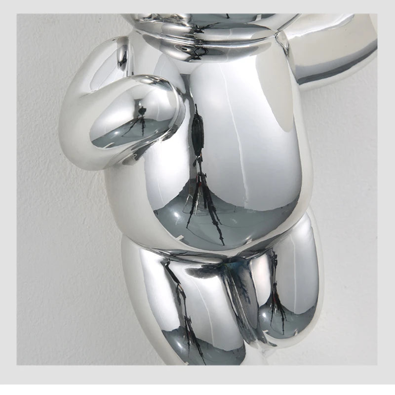Srebrna nowoczesna lampa miś od SANDYHA o błyszczącej metalicznej powierzchni dekoracyjna
