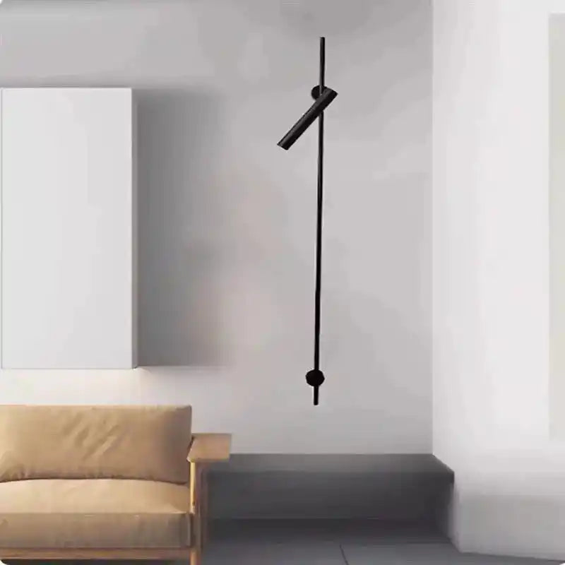 Czarna nowoczesna lampa ścienna wisząca nad szarą ławką i beżową sofą w minimalistycznym wnętrzu