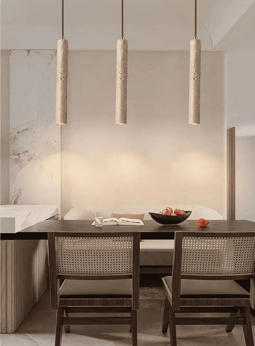 Nowoczesne lampy wiszące w formie długich walców nad stołem w jadalni z drewnianymi krzesłami