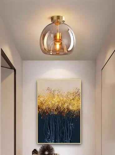 Nowoczesna lampa sufitowa z przezroczystym kloszem i złotymi elementami do salonu