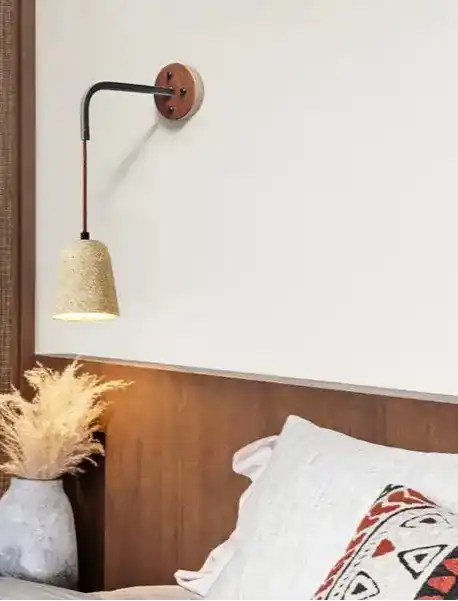 Stylowa lampa ścienna z naturalnym abażurem nad łóżkiem w nowoczesnej sypialni