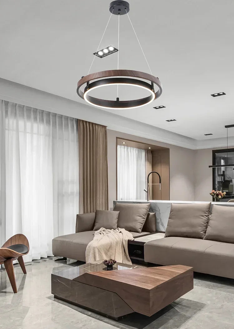 Nowoczesny żyrandol do salonu w designie okrągłym, zawieszony nad nowoczesnym salonem z kanapą