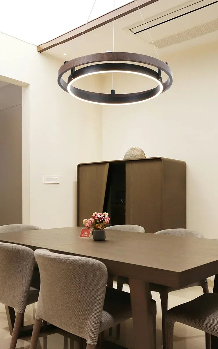 Nowoczesny żyrandol do salonu wiszący nad stołem w eleganckim wnętrzu z jasnymi kolorami