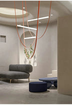 Nowoczesna lampa ze skórzanym paskiem w minimalistycznym wnętrzu z szarymi meblami