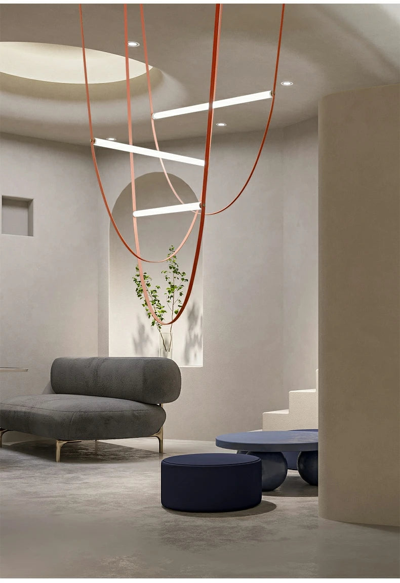 Nowoczesna lampa ze skórzanym paskiem w minimalistycznym wnętrzu z szarymi meblami