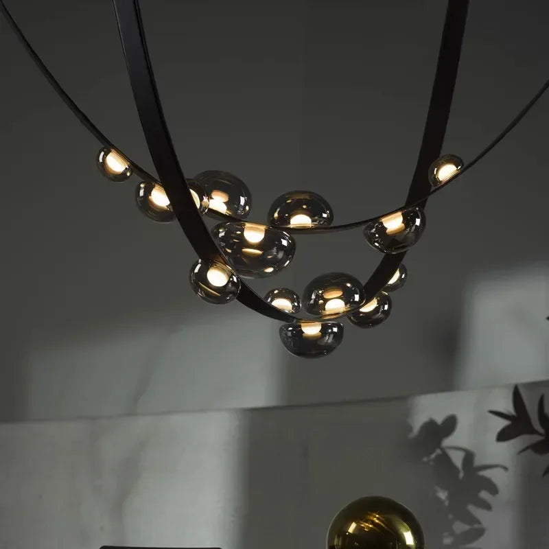 Designerski żyrandol do salonu z metalowymi detalami i okrągłymi źródłami światła