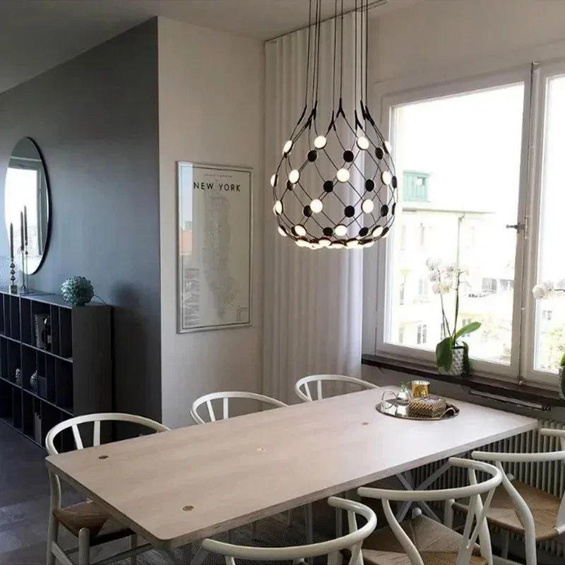 Nowoczesny żyrandol designerski do salonu zawieszony nad stołem w stylowej jadalni