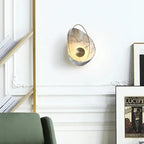 Designerska lampa ścienna z marmurowym akcentem w eleganckim wnętrzu mieszkania