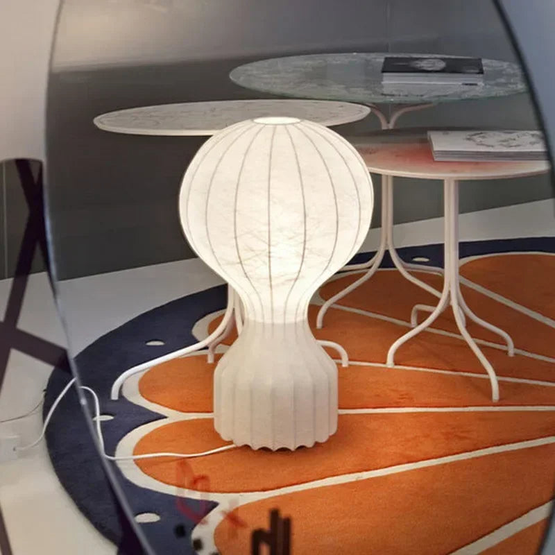 Barcato designerska lampa stołowa o nowoczesnym kształcie na pomarańczowym dywanie