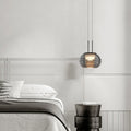Stylowa designerska lampa do sypialni zawieszona nad łóżkiem w nowoczesnym wnętrzu