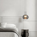 Stylowa designerska lampa do sypialni zawieszona nad łóżkiem w nowoczesnym wnętrzu