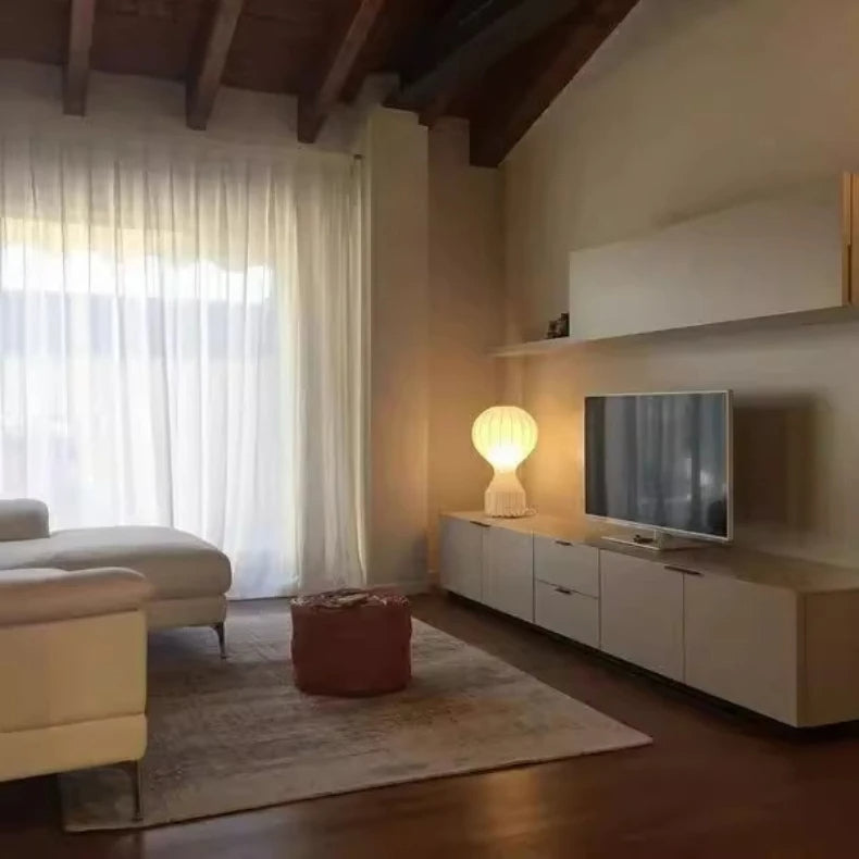 Nowoczesny salon z designerską lampą Barcato na szafce obok telewizora