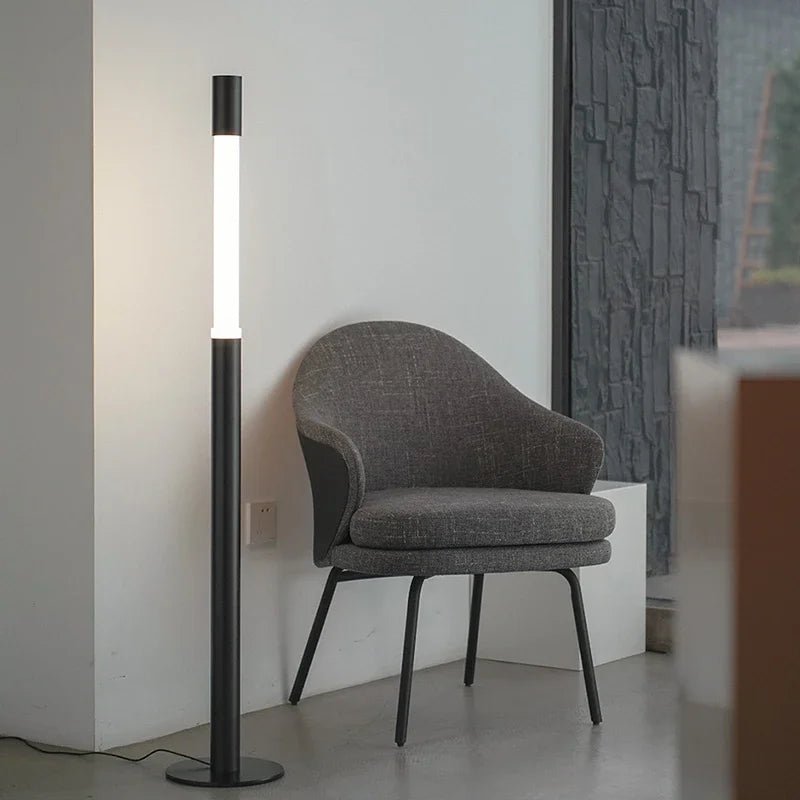 CHUBAN designerska lampa podłogowa w nowoczesnym stylu obok szarego fotela