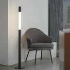 CHUBAN designerska lampa podłogowa w nowoczesnym stylu obok szarego fotela