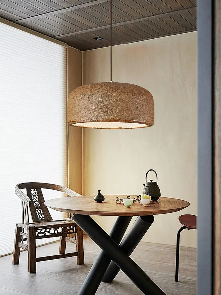 Designerska lampa sufitowa w kształcie abażuru nad drewnianym stołem w nowoczesnym wnętrzu