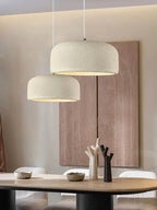 Designerska lampa sufitowa w nowoczesnym wnętrzu z subtelnym oświetleniem nad stołem