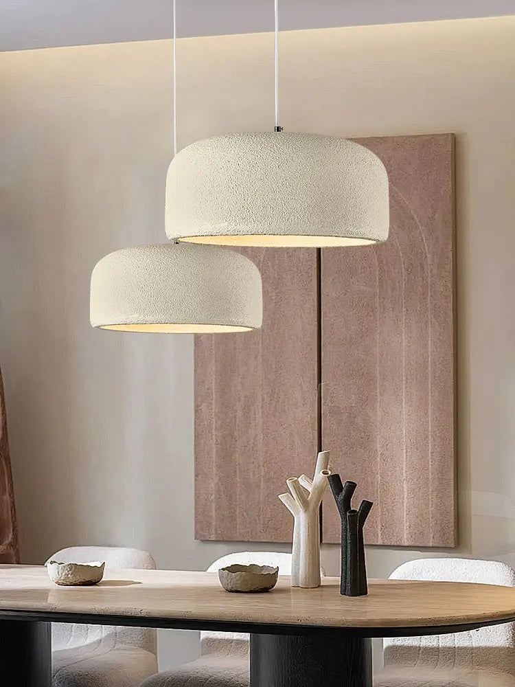 Designerska lampa sufitowa w nowoczesnym wnętrzu z subtelnym oświetleniem nad stołem