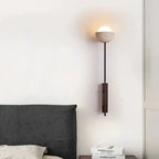 Minimalistyczny kinkiet ścienny z okrągłą mleczną kloszem nad łóżkiem