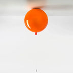Kolorowa lampa balonowa w pomarańczowym kolorze zawieszona na suficie jako nowoczesne oświetlenie
