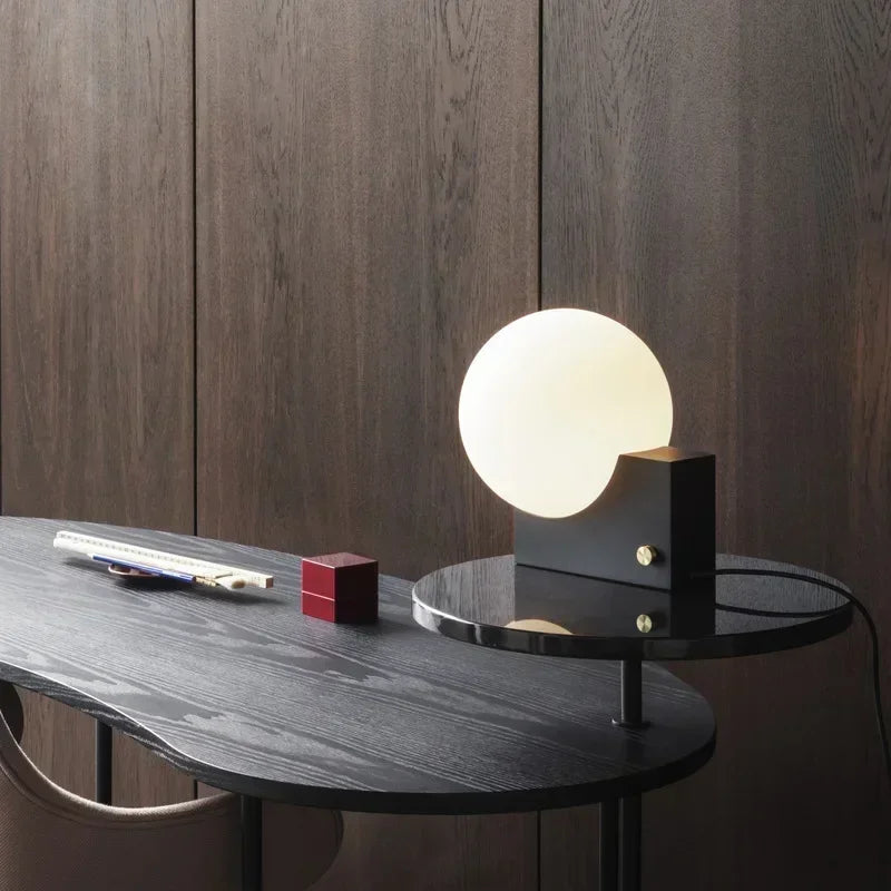 Nowoczesna lampa biurkowa JIANKEXING ze szklaną kulą na czarnym stoliku w minimalistycznym wnętrzu