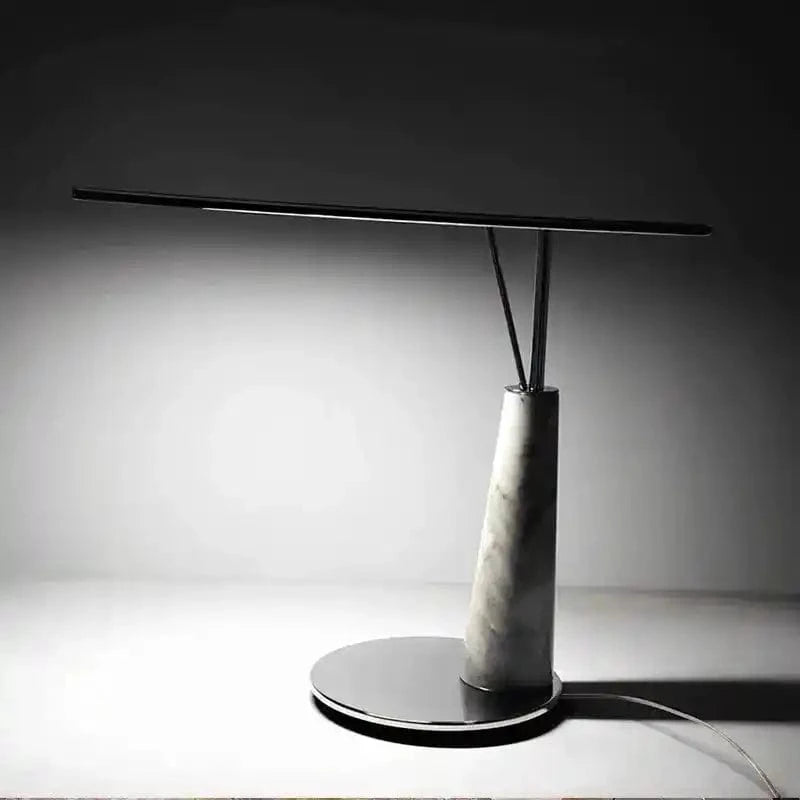 Nowoczesna lampa biurkowa z marmurową podstawą i cienkim czarnym ramieniem do oświetlenia stanowiska pracy