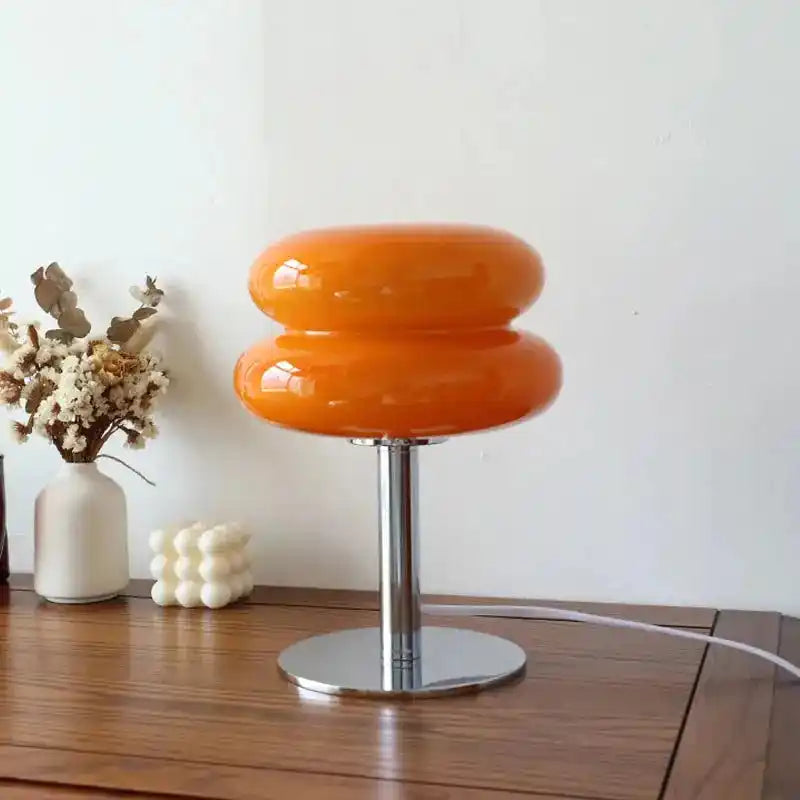 Pomarańczowa lampa biurkowa yueyi z nowoczesnym chromowanym stojakiem na drewnianym stole