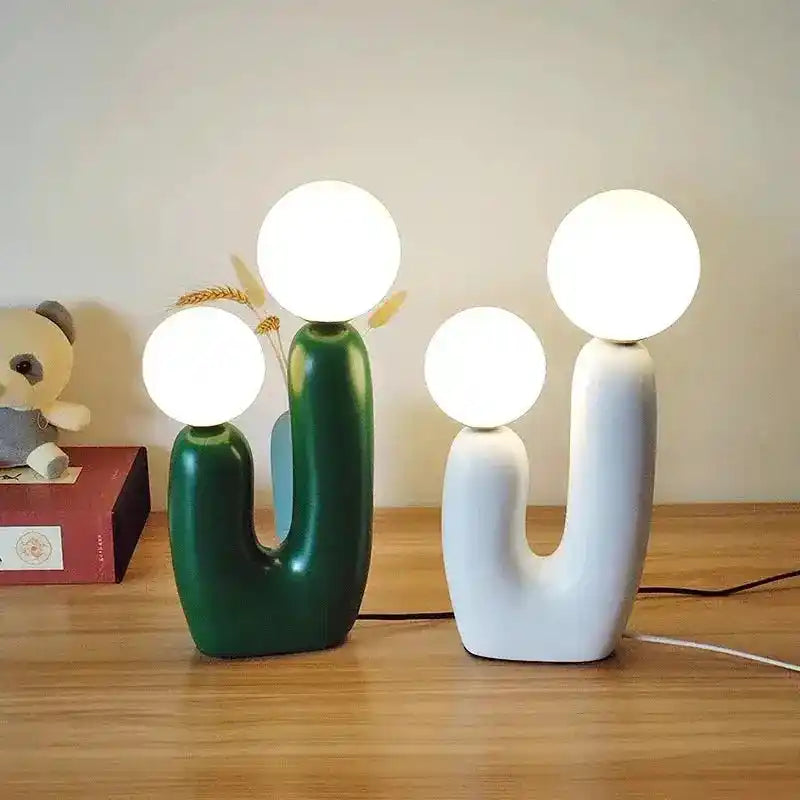 Nowoczesna lampa biurkowa w kształcie kaktusa z dwoma kulistymi źródłami światła w kolorze zielonym i białym
