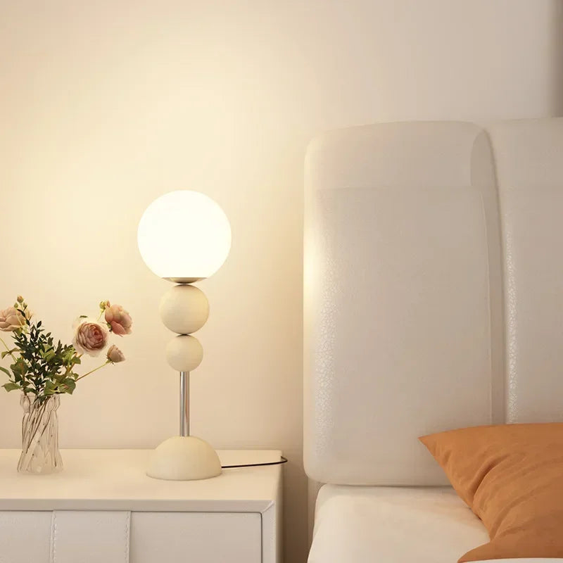 SANDYHA lampa stojąca z kulistym kloszem w nowoczesnym minimalistycznym stylu na stoliku nocnym
