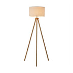 Elegancka lampa stojąca do salonu z drewnianą podstawą na trzech nogach i jasnym abażurem
