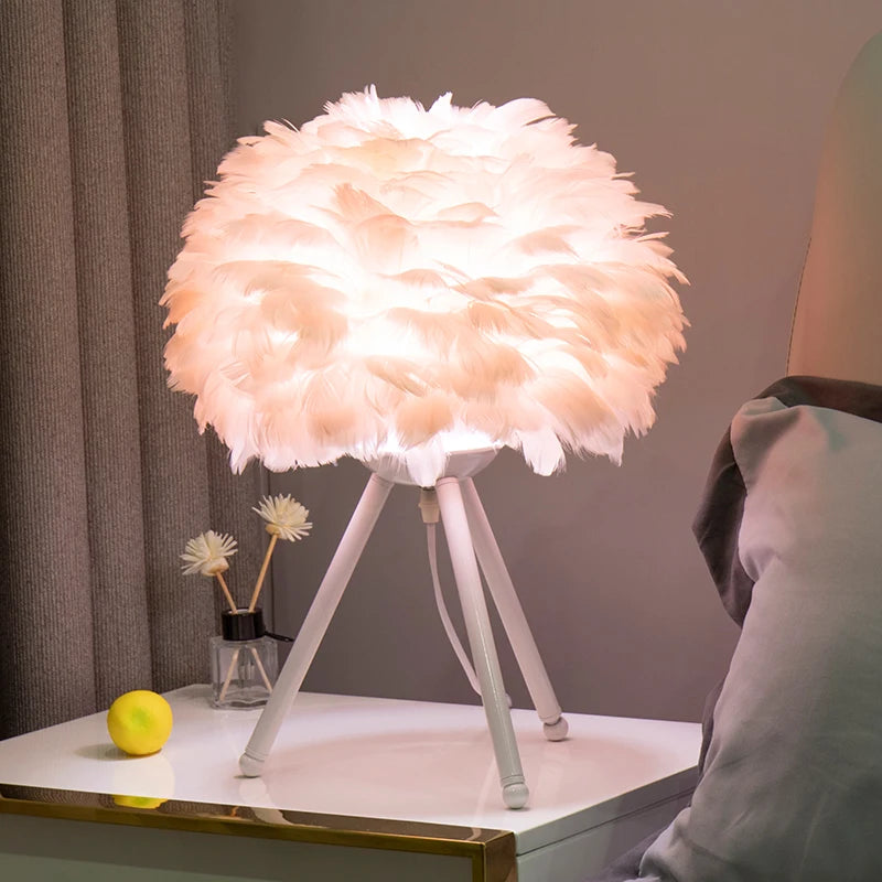Lampa stołowa WHGL light z kloszem z białych piór na trójnogu o dekoracyjnym charakterze