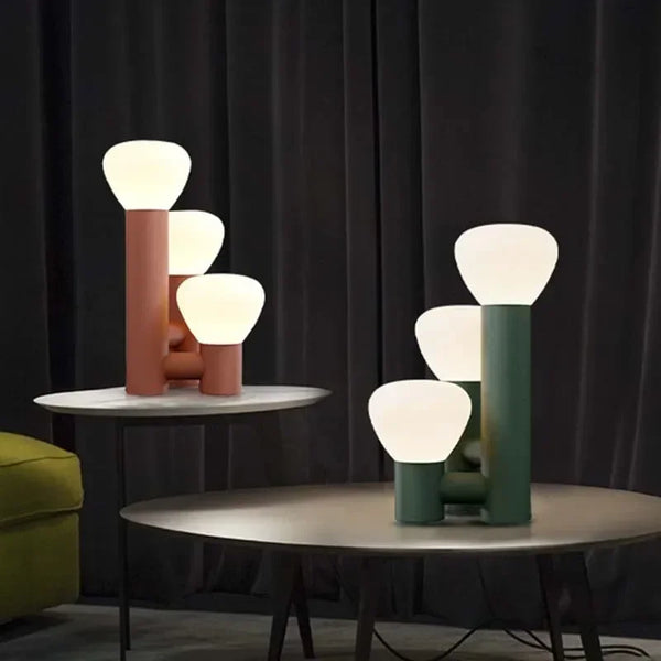 Lampa stołowa Velmera z trzema białymi kloszami na brązowej i zielonej podstawie