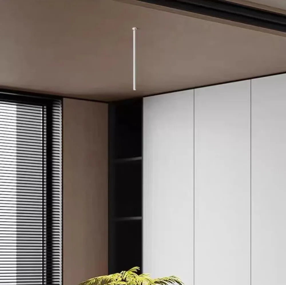 Minimalistyczna biała lampa sufitowa wisząca na długim przewodzie w nowoczesnym wnętrzu