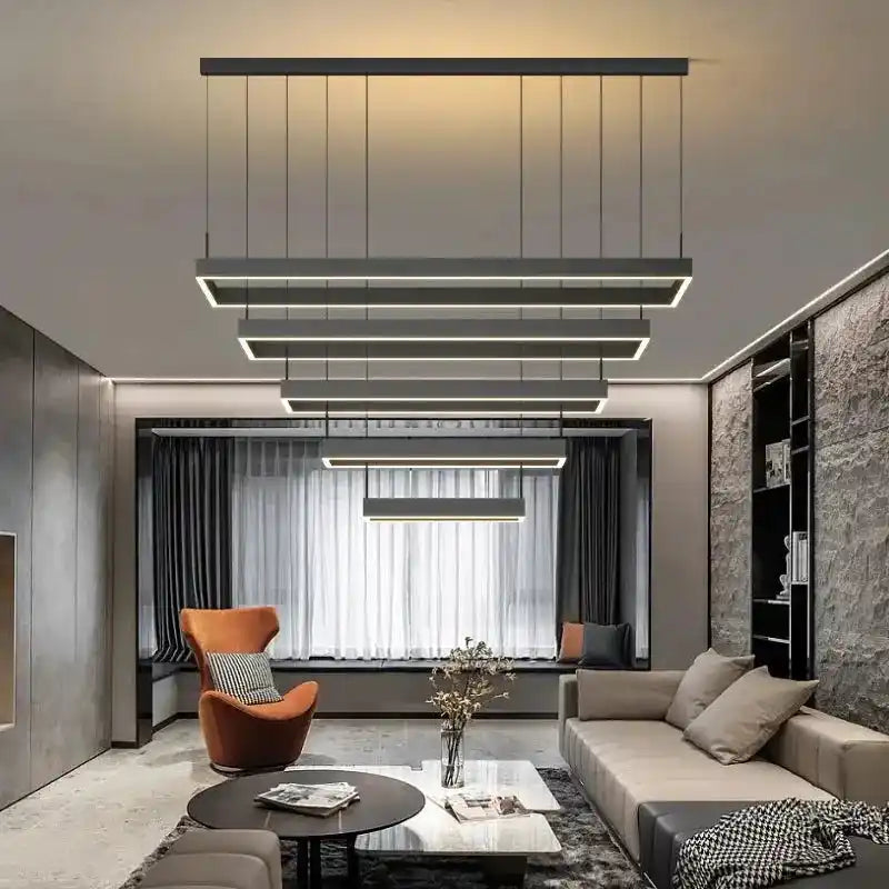 nowoczesna lampa sufitowa Busmos z geometrycznym designem w salonie z szarą sofą i pomarańczowym fotelem