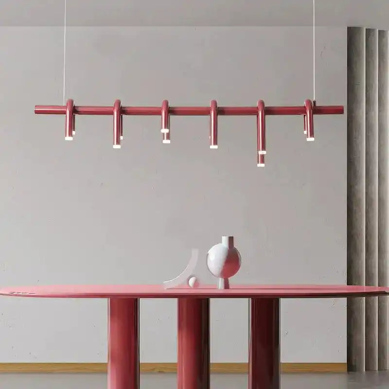 Nowoczesna czerwona lampa sufitowa wisząca nad stołem w minimalistycznym wnętrzu