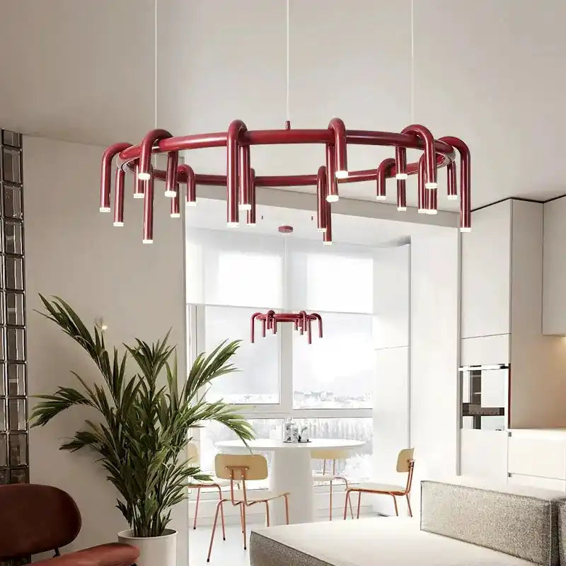 Nowoczesna czerwona lampa sufitowa z wieloma źródłami światła w jasnym salonie z rośliną