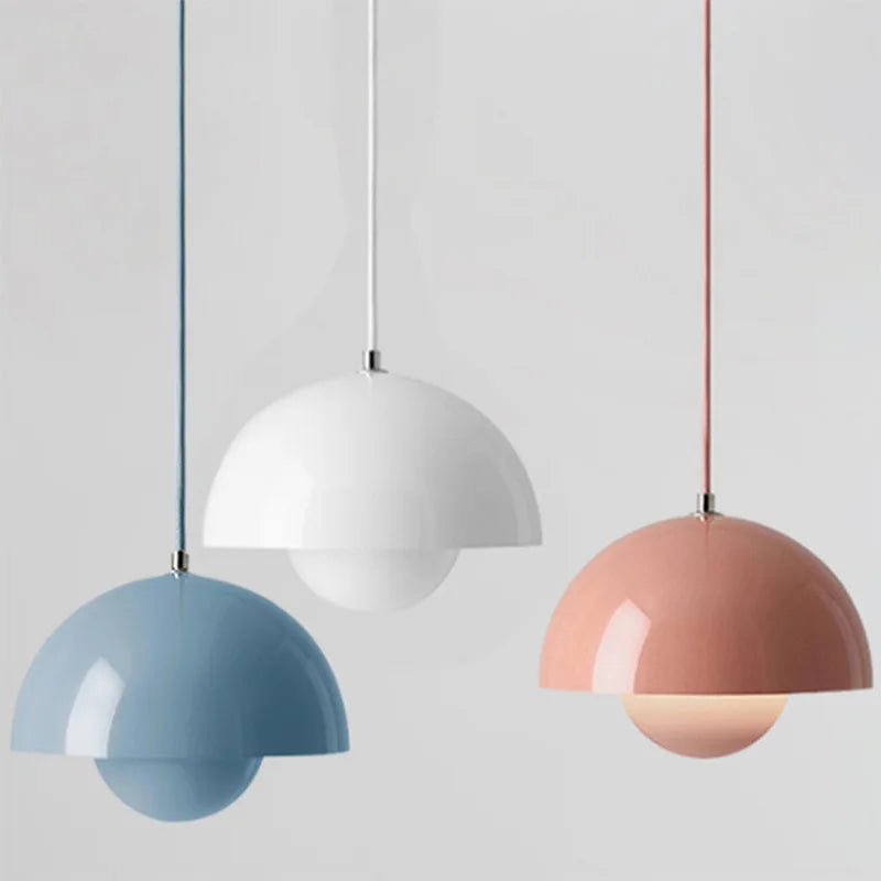 Trzy kolorowe lampy sufitowe w kształcie półkuli: niebieska, biała i różowa, idealne do nowoczesnych wnętrz