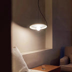 Minimalistyczna lampa wisząca o okrągłym kształcie w nowoczesnym salonie z ciepłym światłem