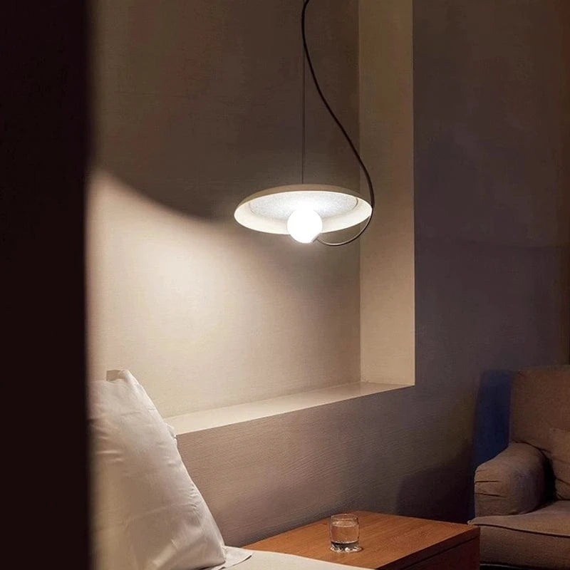 Minimalistyczna lampa wisząca o okrągłym kształcie w nowoczesnym salonie z ciepłym światłem