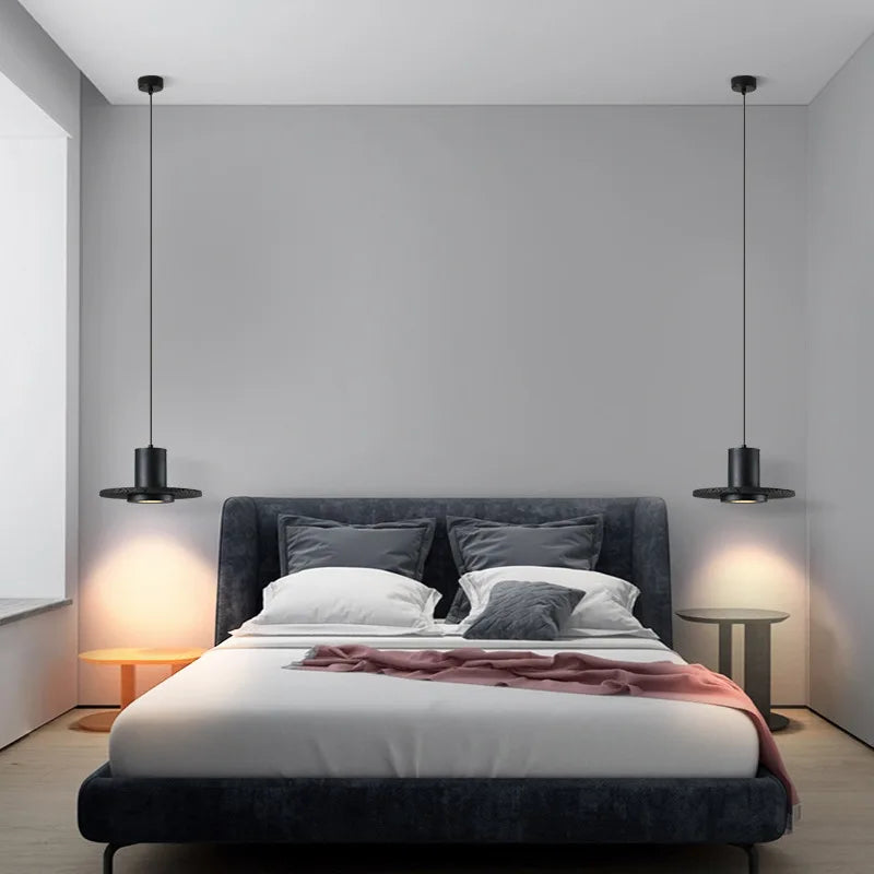 Nowoczesna lampa wisząca YRB czarna nad łóżkiem w stylowej sypialni z szarymi ścianami