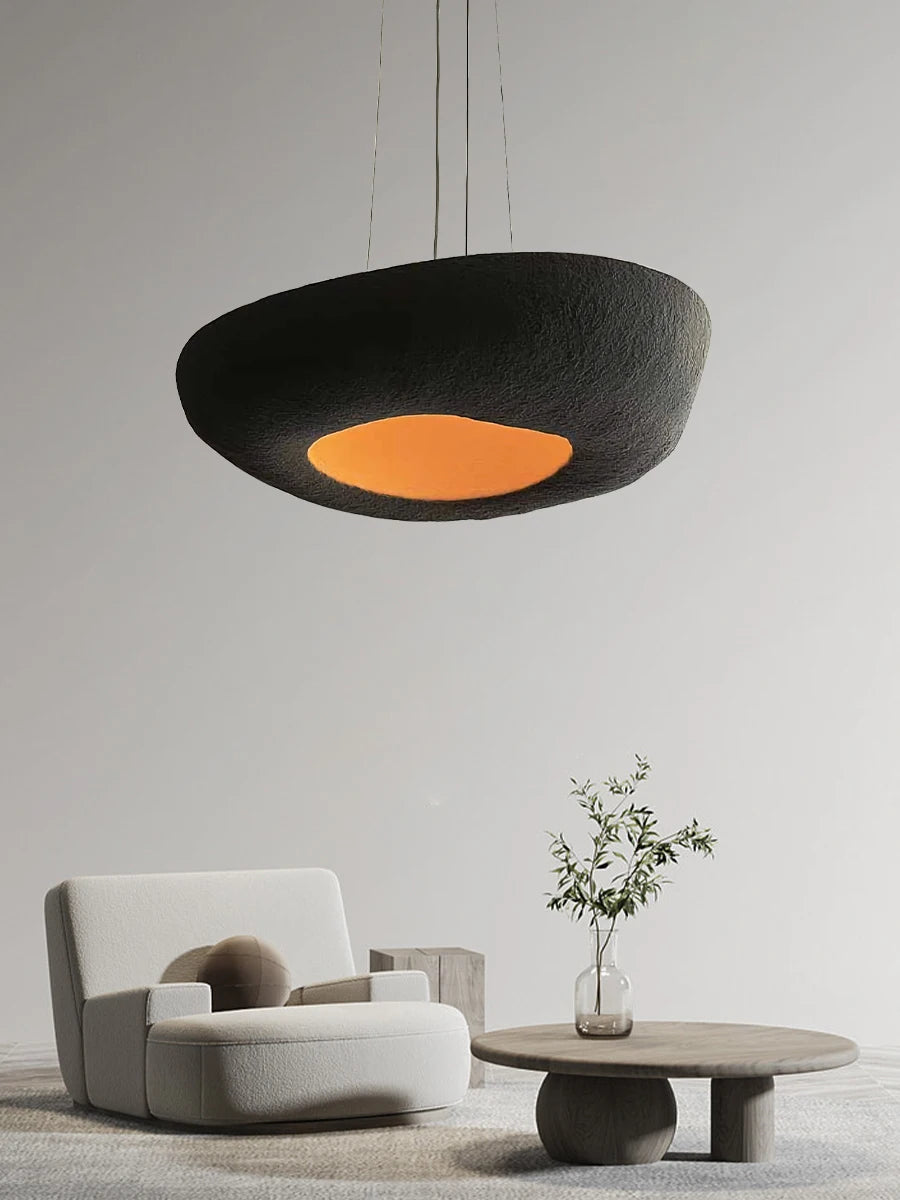 Artpad nowoczesna czarna lampa wisząca z pomarańczowym światłem w minimalistycznym salonie