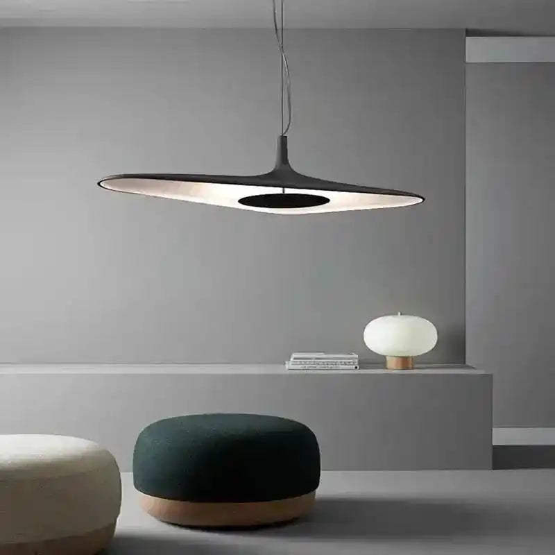 Lampa wisząca minimalistyczna Luk Star w nowoczesnym wnętrzu z szarą ścianą i pufami