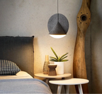 Blonche lampa wisząca nowoczesna szara nad stolikiem nocnym z rośliną przy łóżku