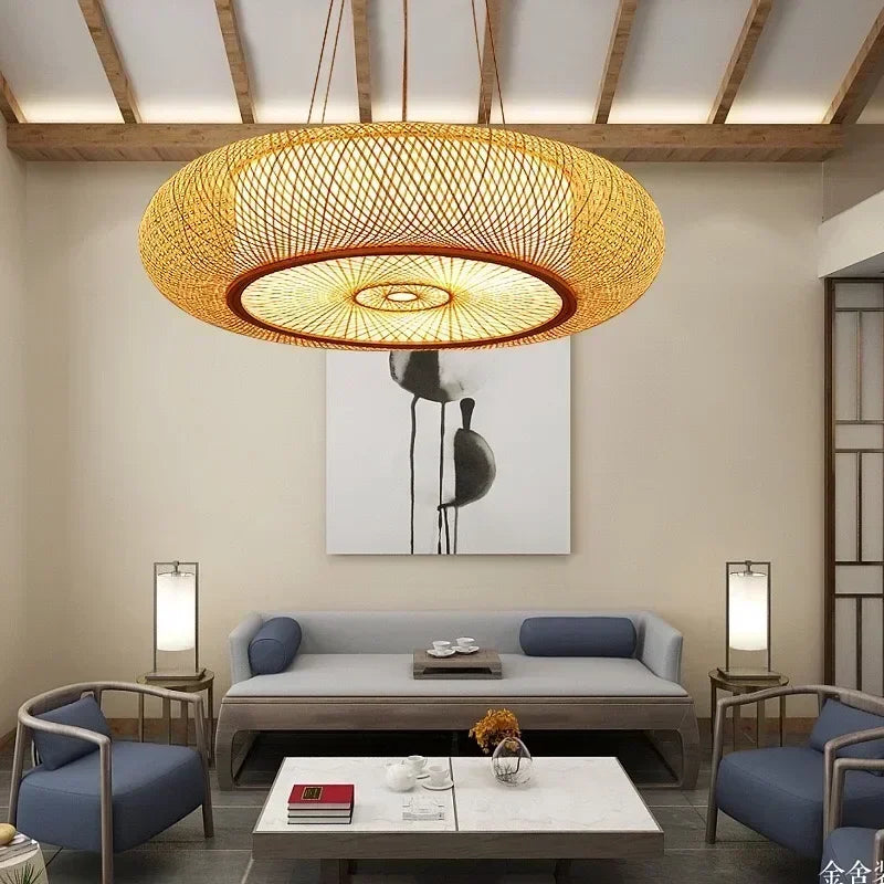 Nowoczesna lampa wisząca z plecionym abażurem w salonie z niebieskimi krzesłami i szarą sofą
