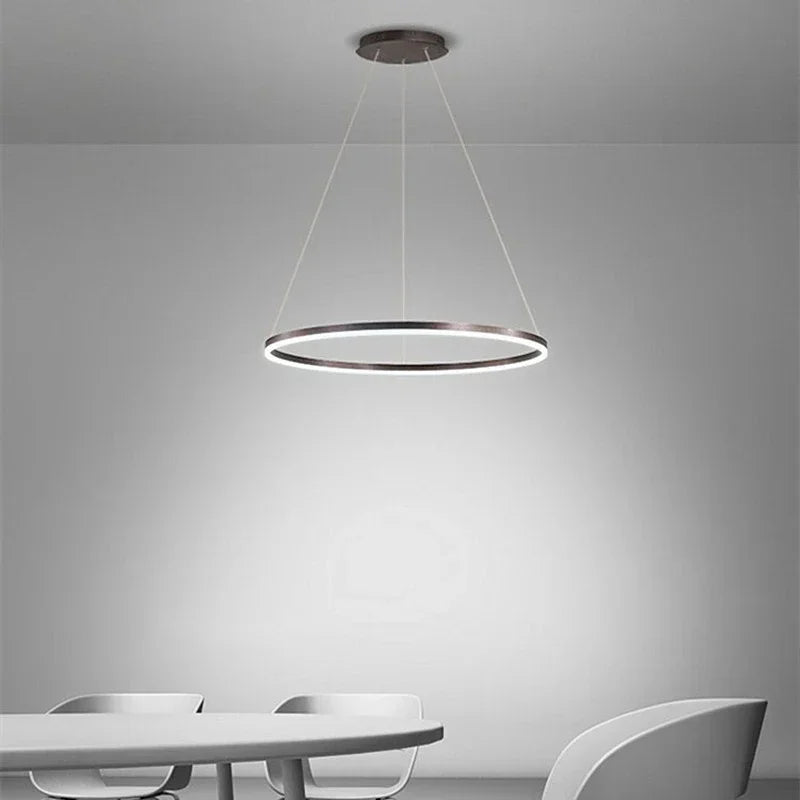 Nowoczesna lampa wisząca DAMIASMIL w kształcie okręgu nad białym stołem w minimalistycznym wnętrzu