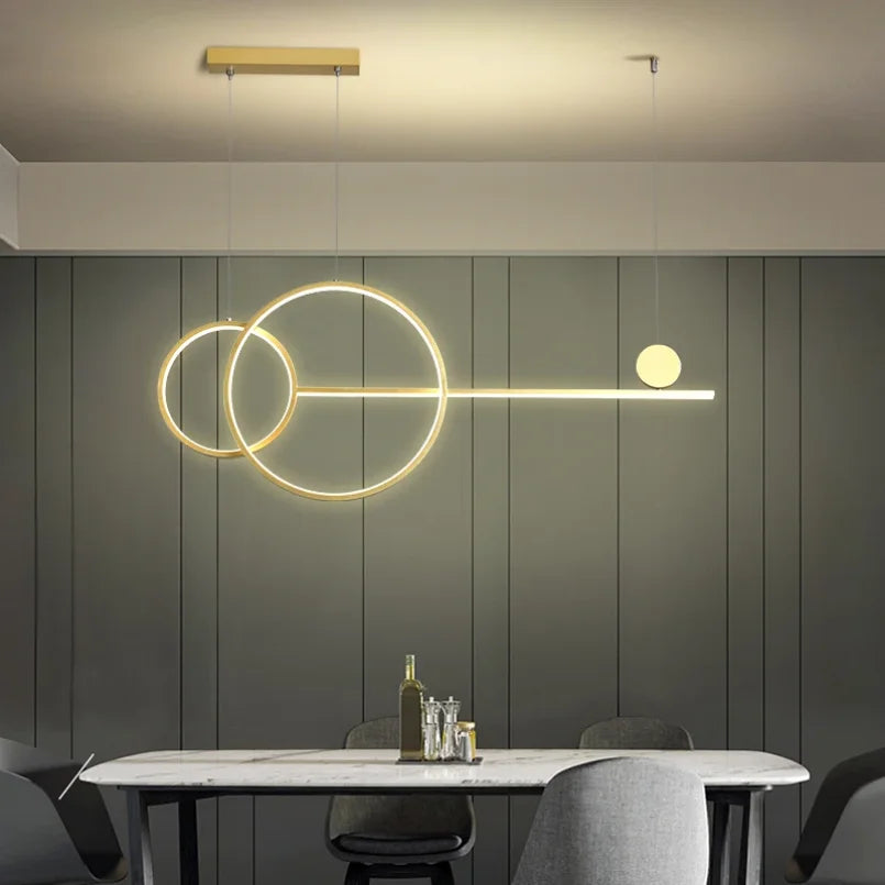Nowoczesna lampa wisząca z geometrycznymi kształtami i ciepłym światłem na tle ciemnej ściany