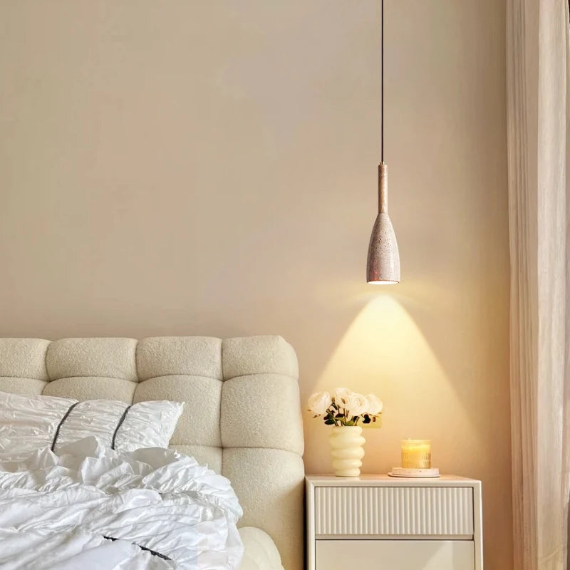 Nowoczesna lampa z kamienia zawieszona nad łóżkiem w eleganckim wnętrzu sypialni