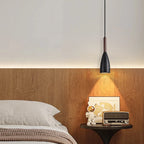 Lampa z kamienia w nowoczesnym wnętrzu, zawieszona nad łóżkiem z drewnianą ścianą i dekoracjami