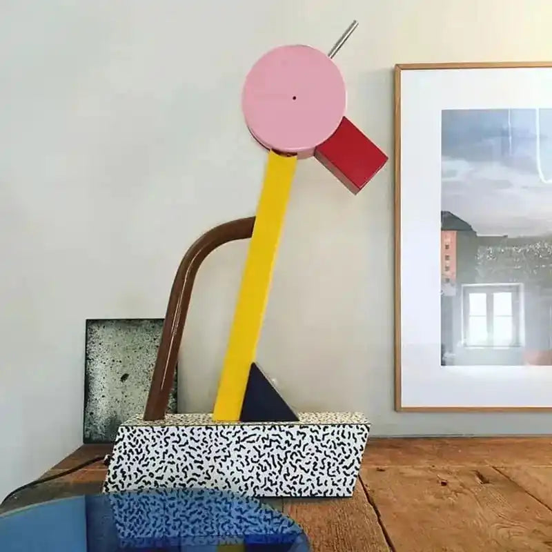 Kolorowa lampa biurkowa KRKR o nowoczesnym geometrycznym designie z elementami różu, żółci i czerwieni